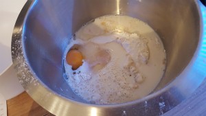 Den Germ und die Milch zu den restlichen Zutaten in die Schüssel geben